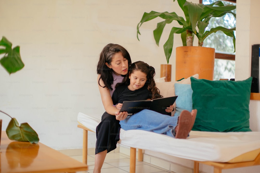 a woman sitting on a couch with a little girl