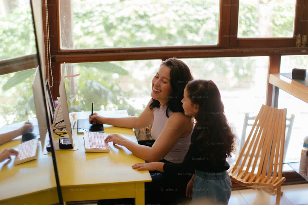 Una mujer sentada en un escritorio con una niña pequeña