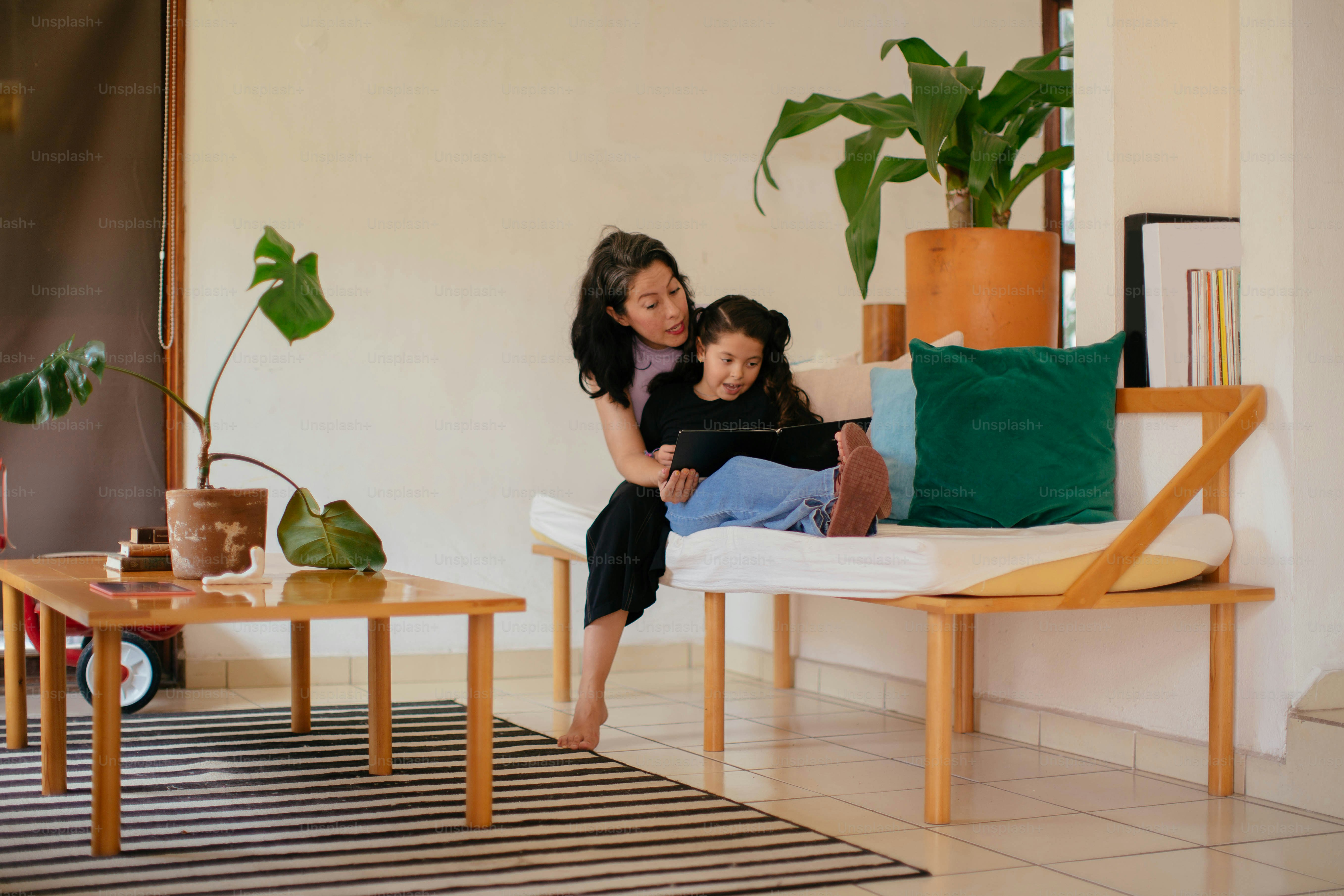 a woman and a girl sitting on a couch