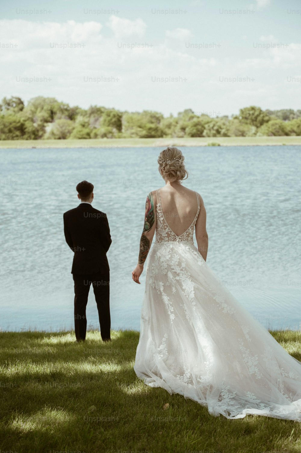 a man and a woman standing next to a body of water