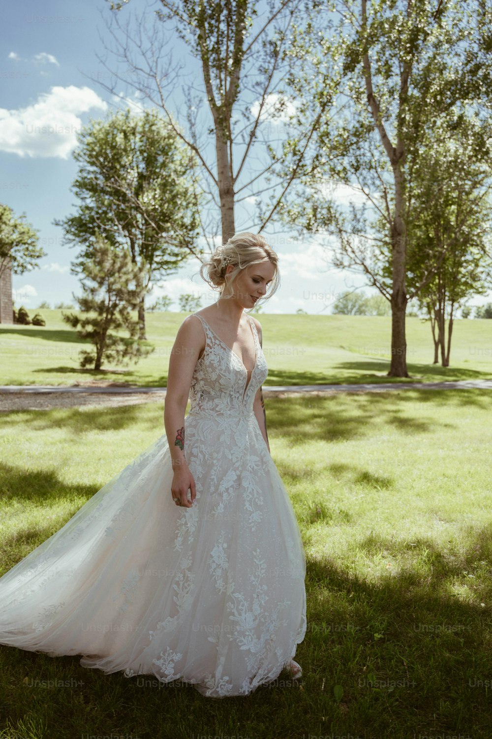 a woman in a wedding dress standing in the grass