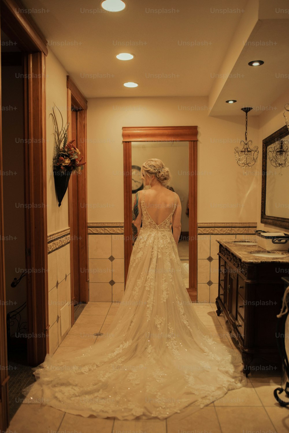 uma mulher em um vestido de noiva em pé em frente a um espelho