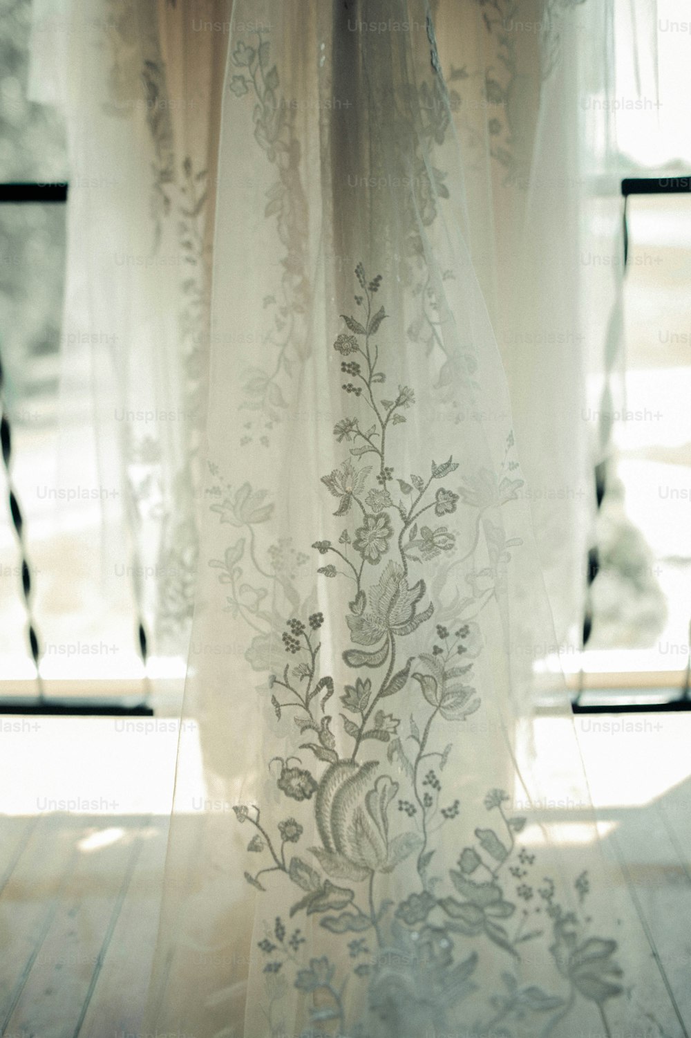 a close up of a sheer curtain with flowers on it