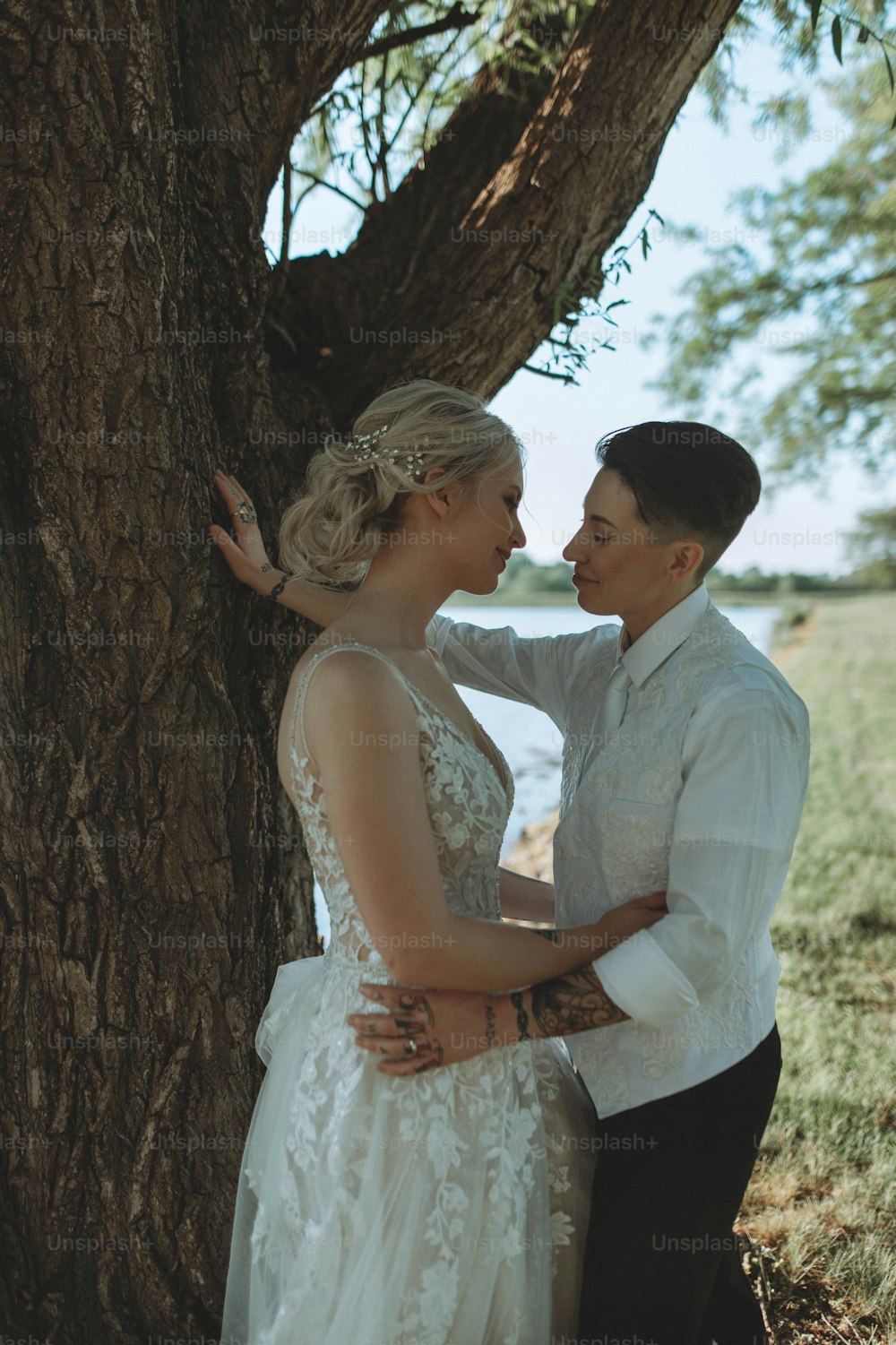 a man and a woman standing next to a tree