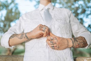 a man in a white shirt and tie with tattoos on his arms