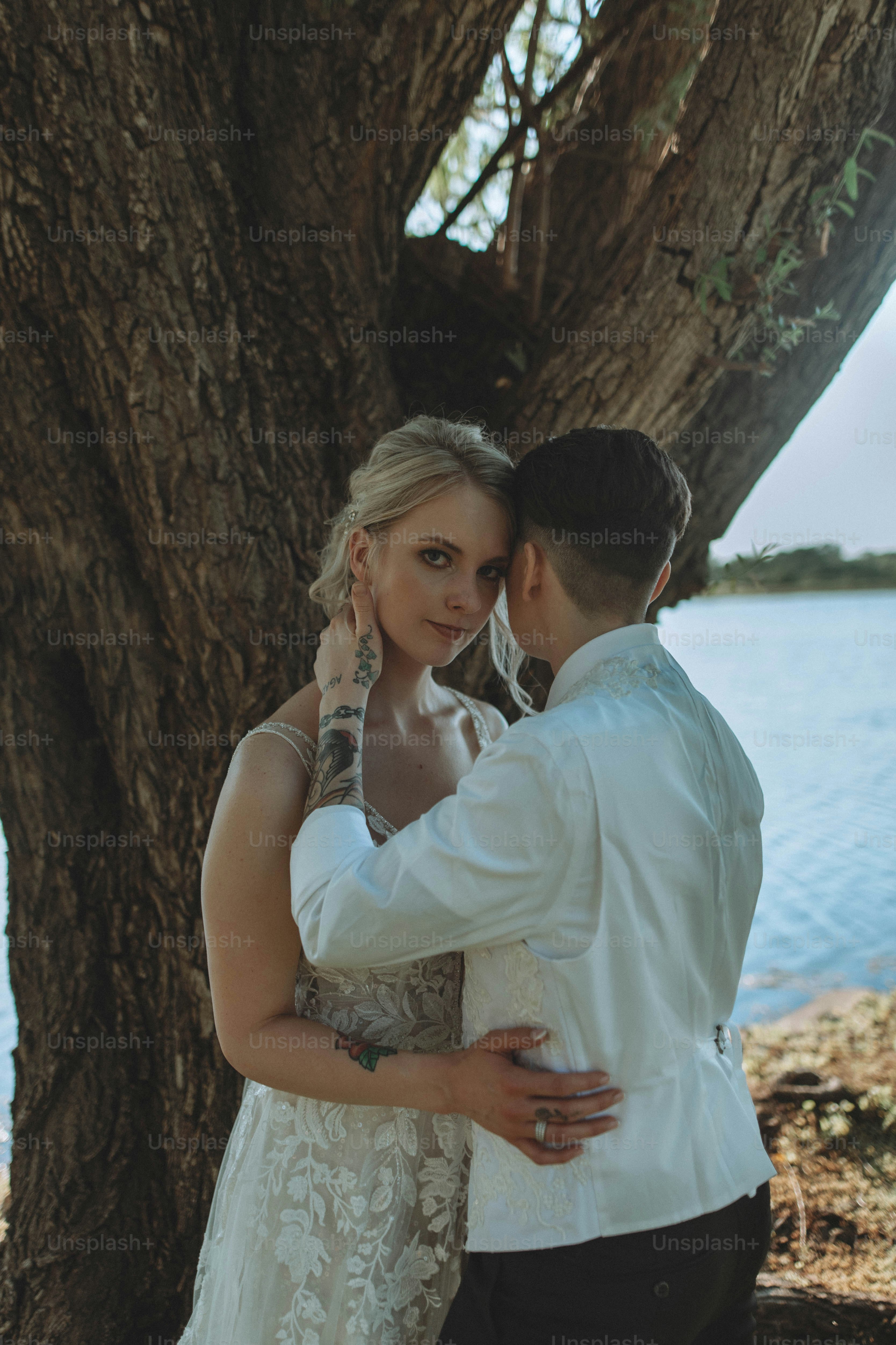 a man and a woman standing next to a tree