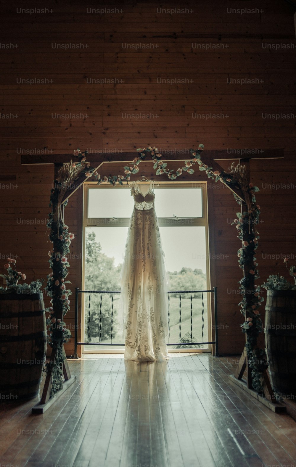 um vestido de noiva pendurado em frente a uma janela