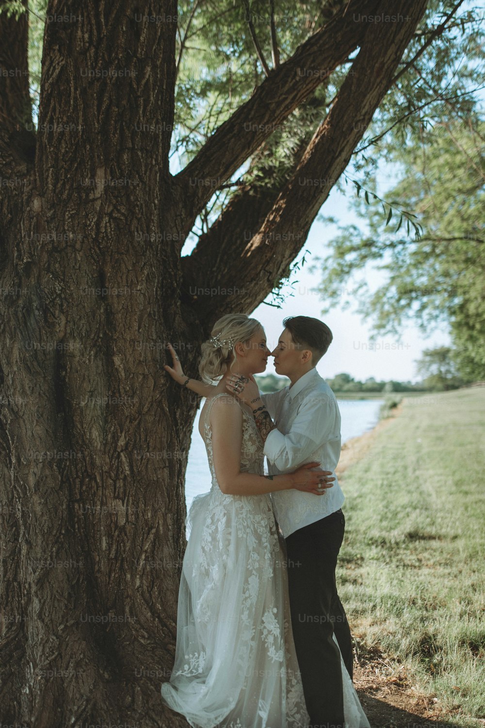 un uomo e una donna in piedi accanto a un albero
