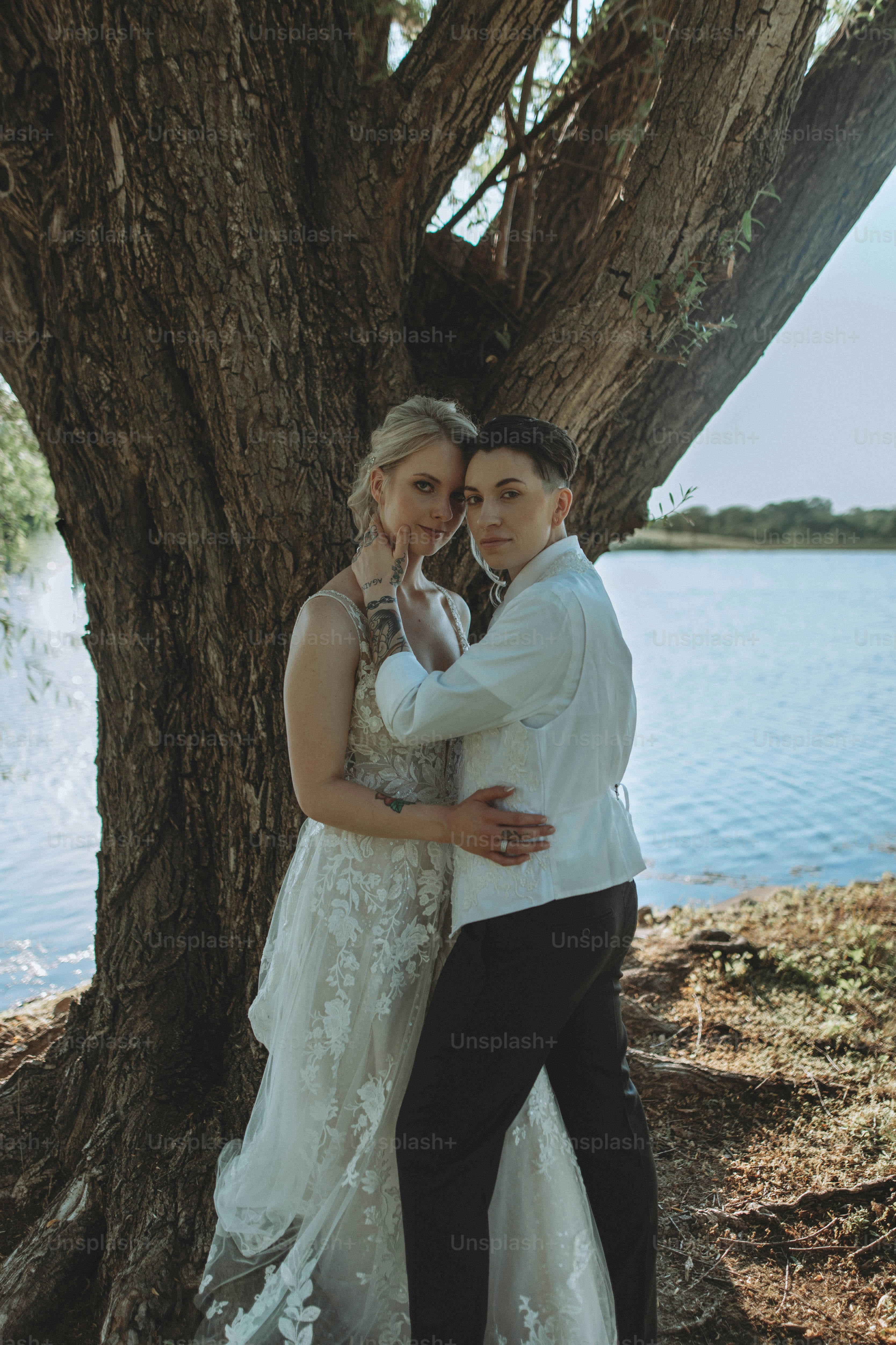 a man and a woman standing next to a tree
