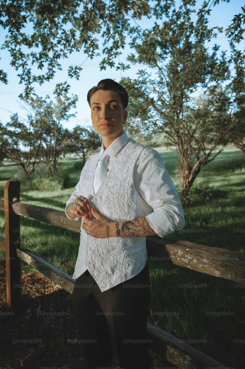 a man standing in front of a wooden fence