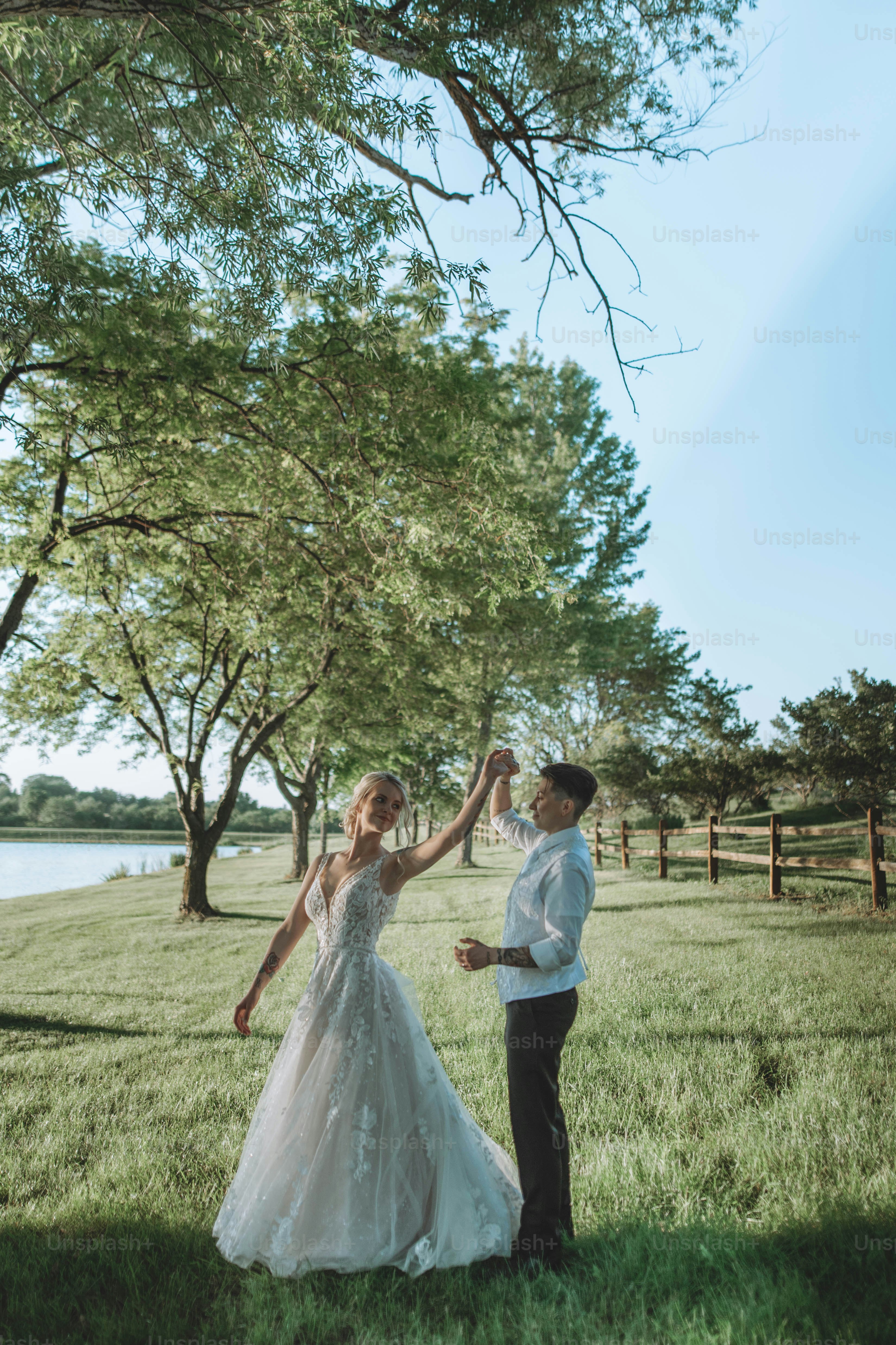 a bride and groom dancing in a field
