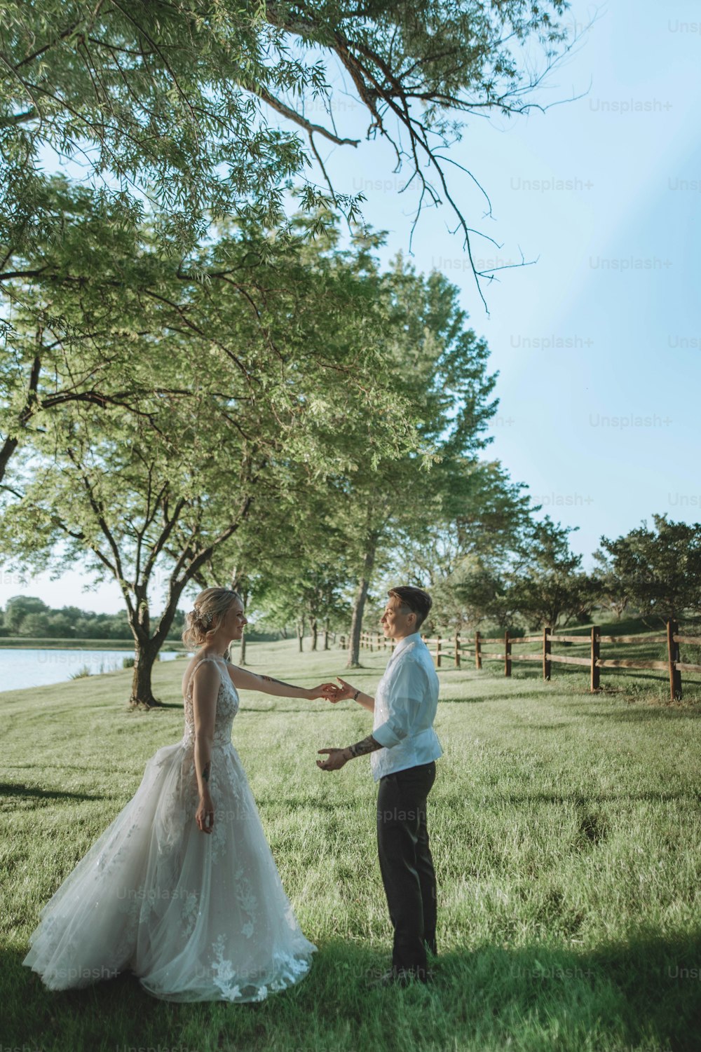 ein Brautpaar, das Händchen hält, auf einem Feld