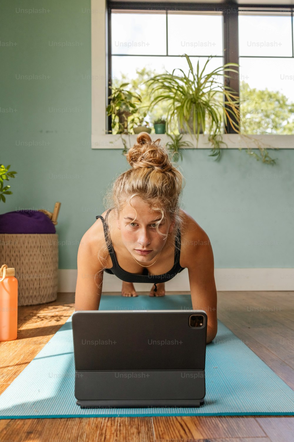 une femme sur un tapis de yoga utilisant un ordinateur portable