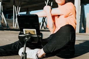a woman sitting on the ground with a laptop