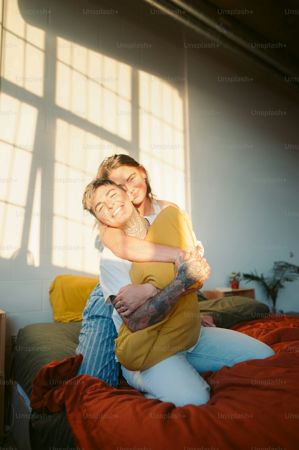 a woman hugging a man on top of a bed