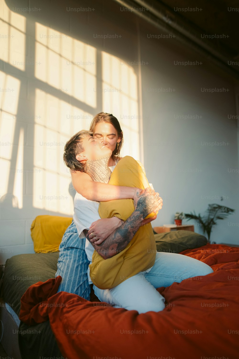 Una mujer abrazando a un hombre encima de una cama