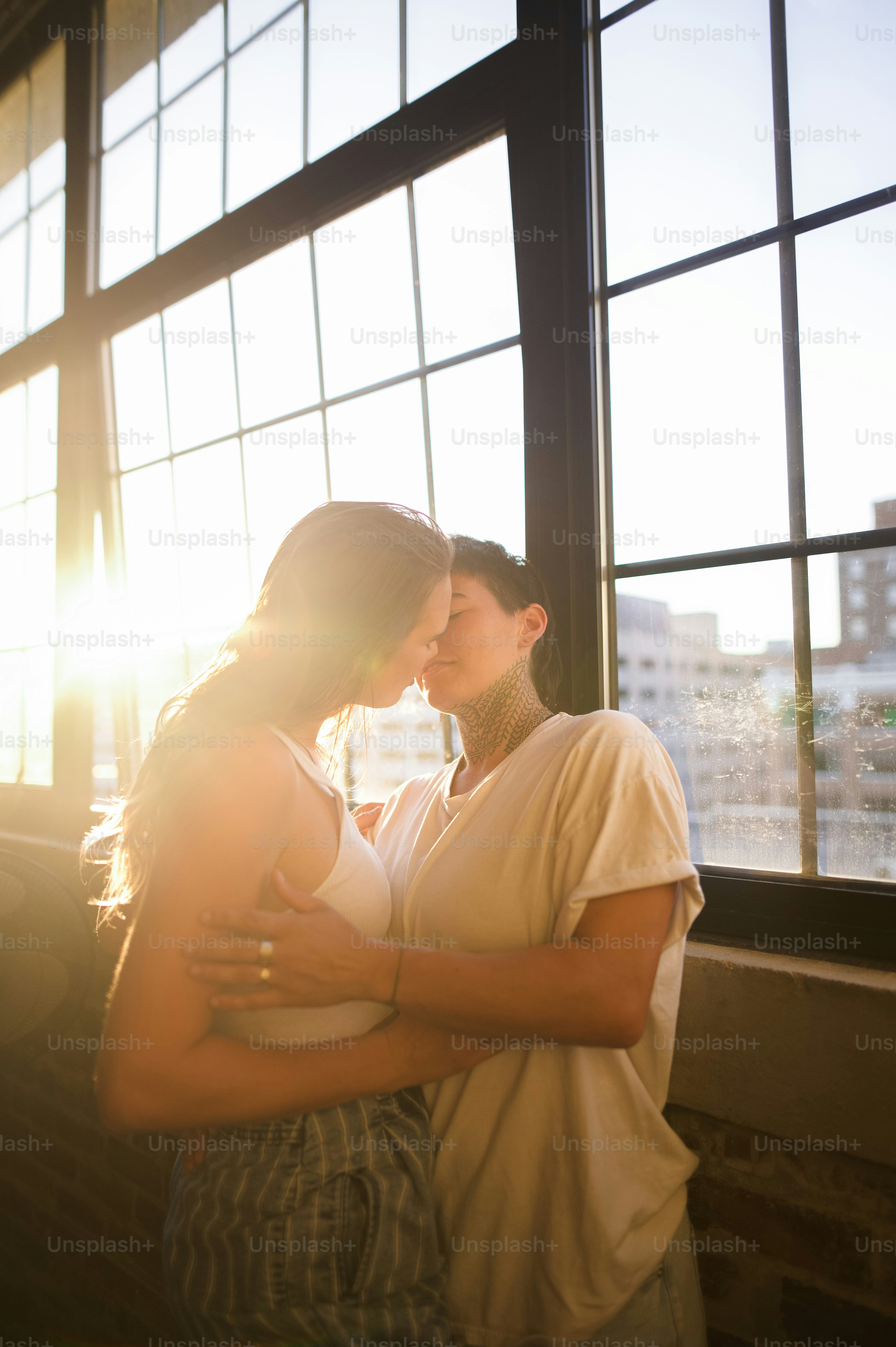 un couple de femmes debout l’une à côté de l’autre près d’une fenêtre