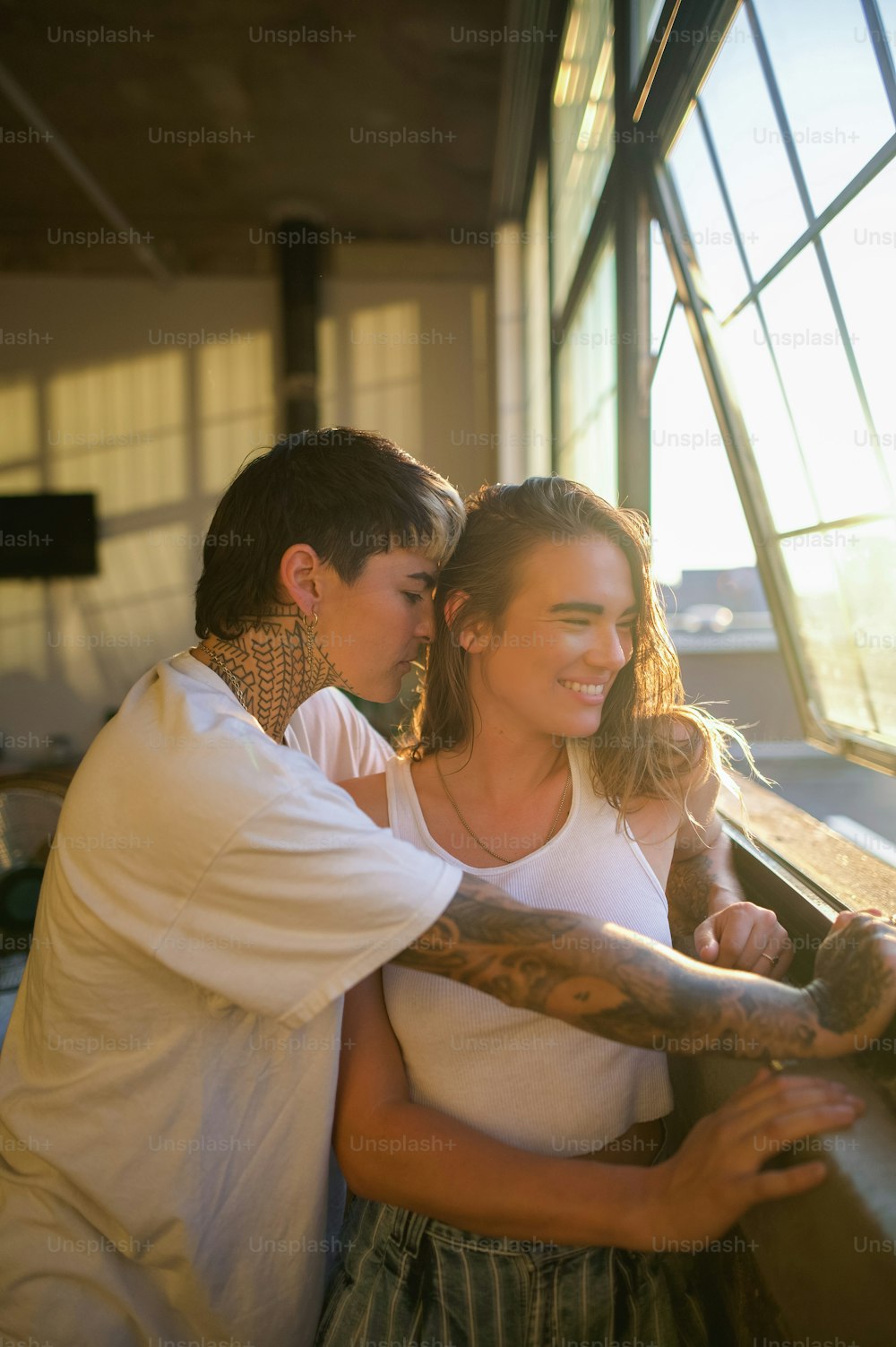 a man and a woman leaning against a window