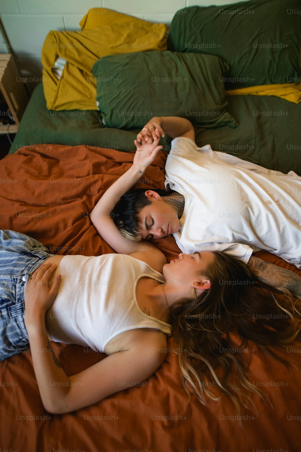 a couple of people laying on top of a bed