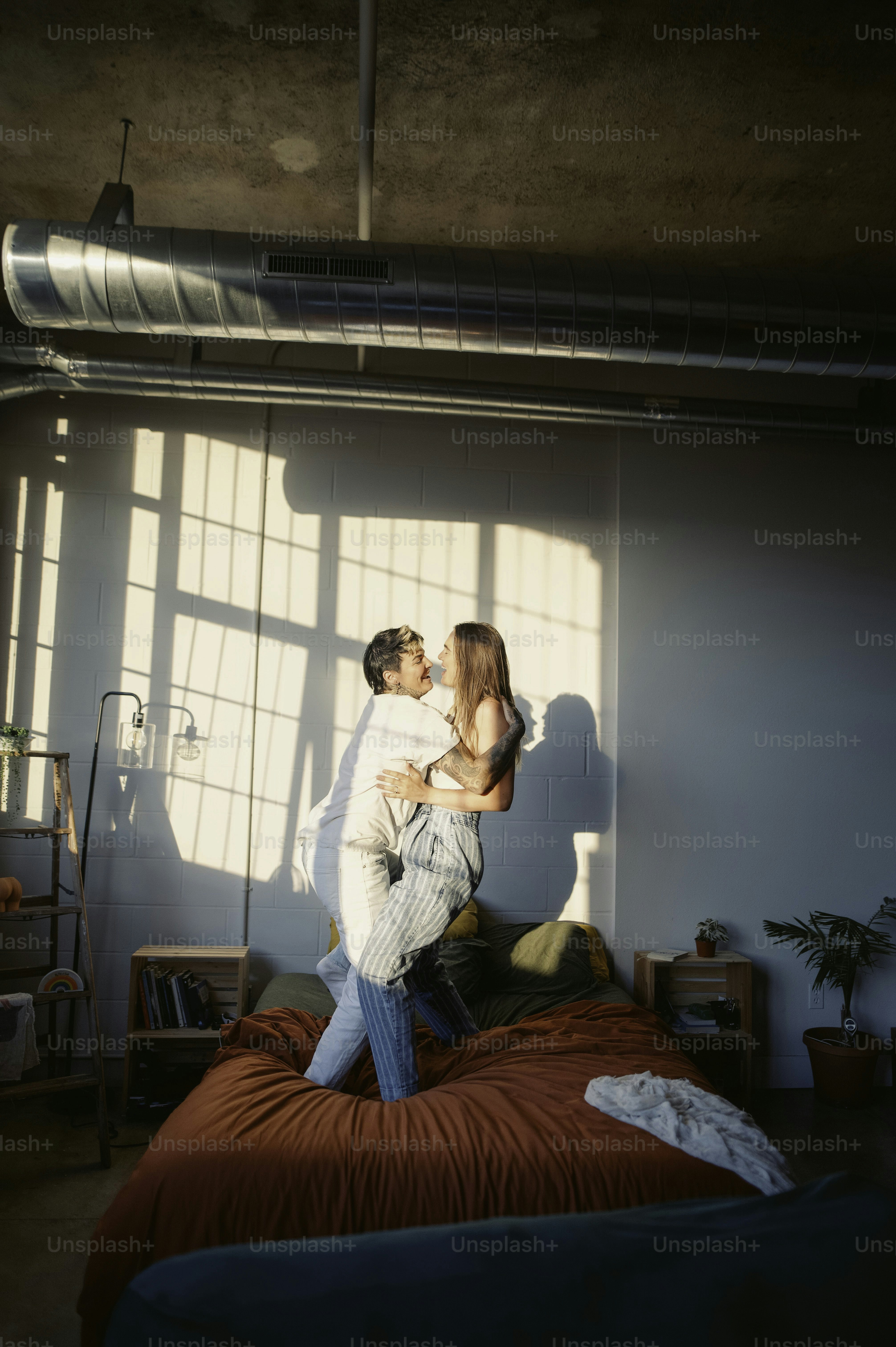 um homem e uma mulher em pé sobre uma cama