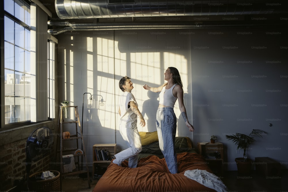 a man and a woman standing on a bed