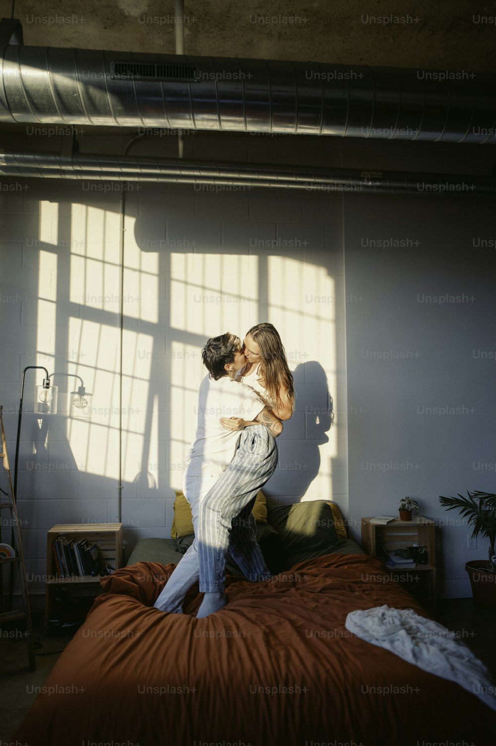 um homem e uma mulher em pé sobre uma cama