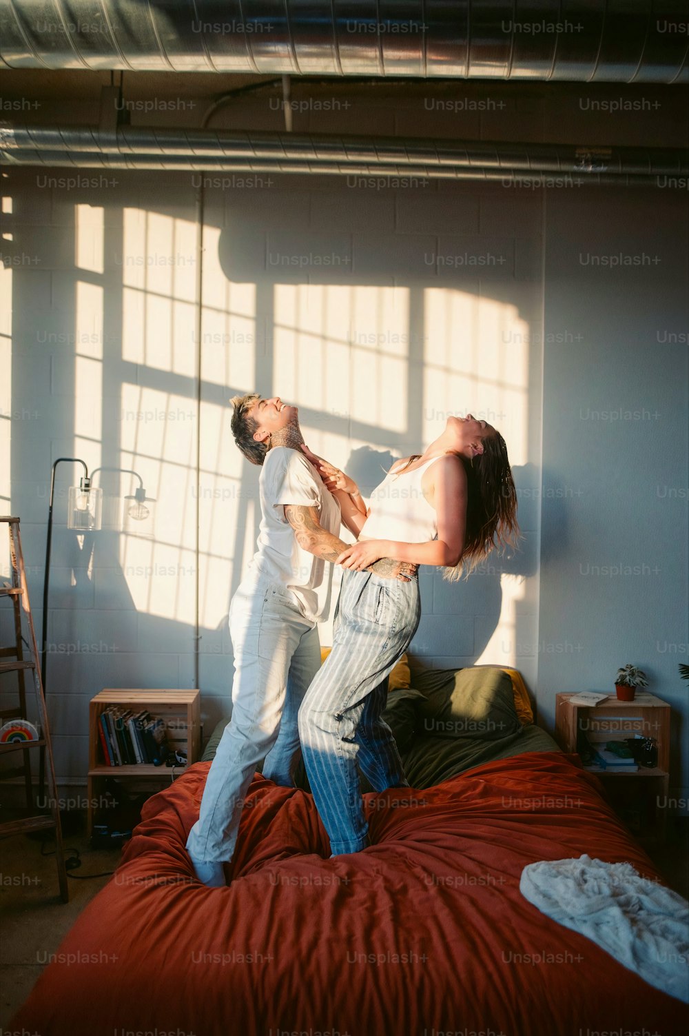 a man and a woman standing on a bed