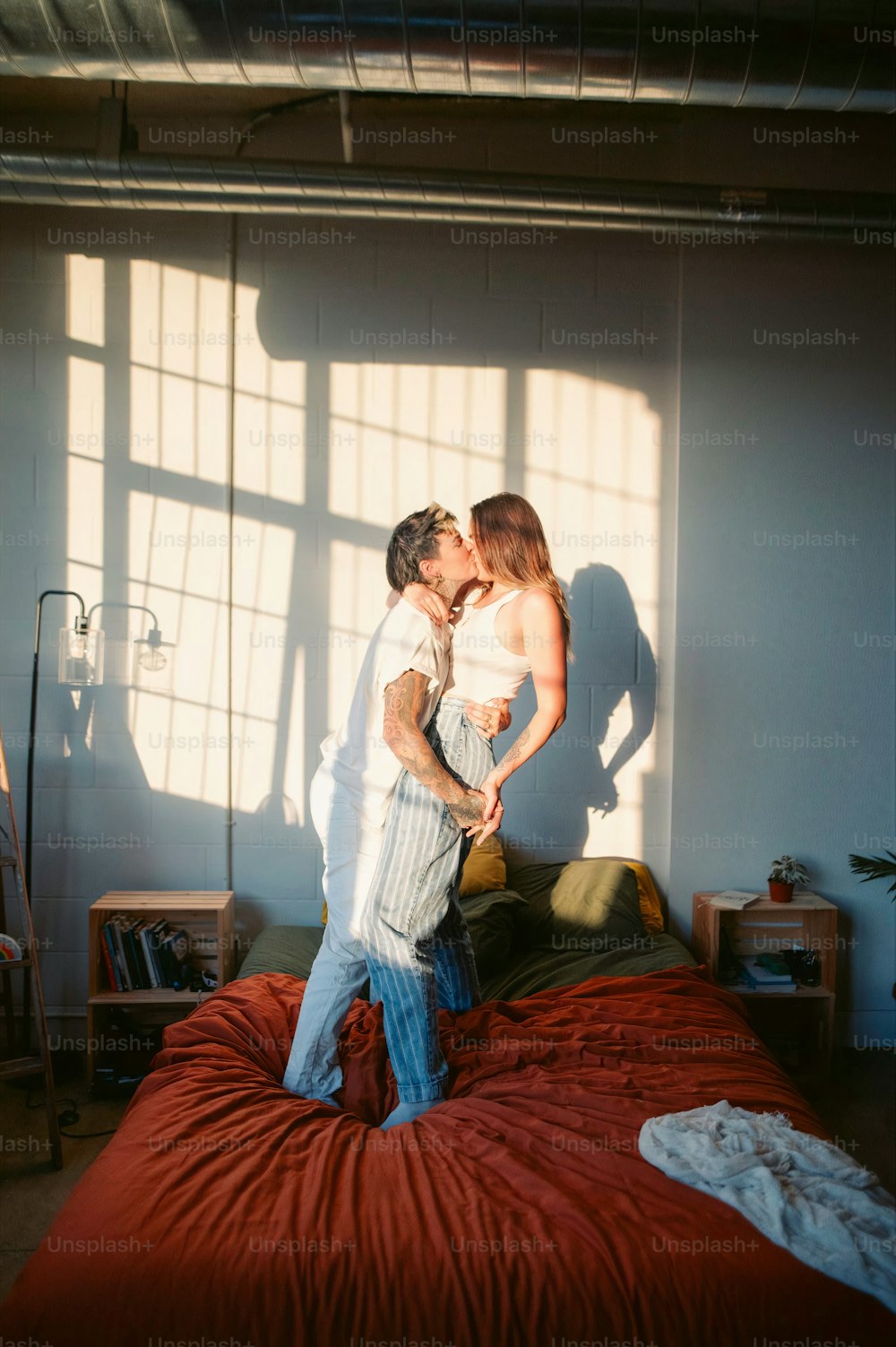 a man and a woman kissing on a bed