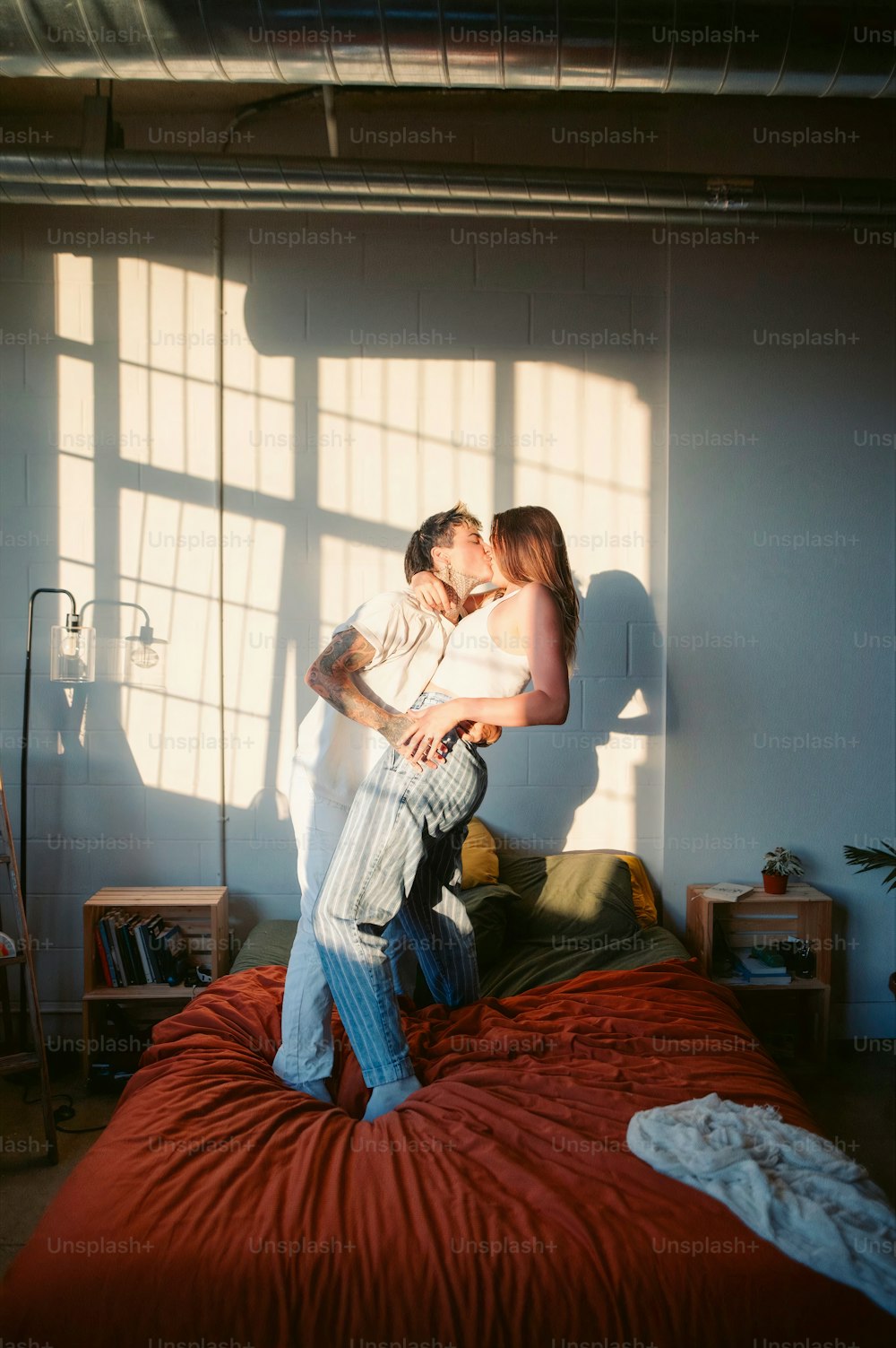Um homem e uma mulher estão se beijando em uma cama