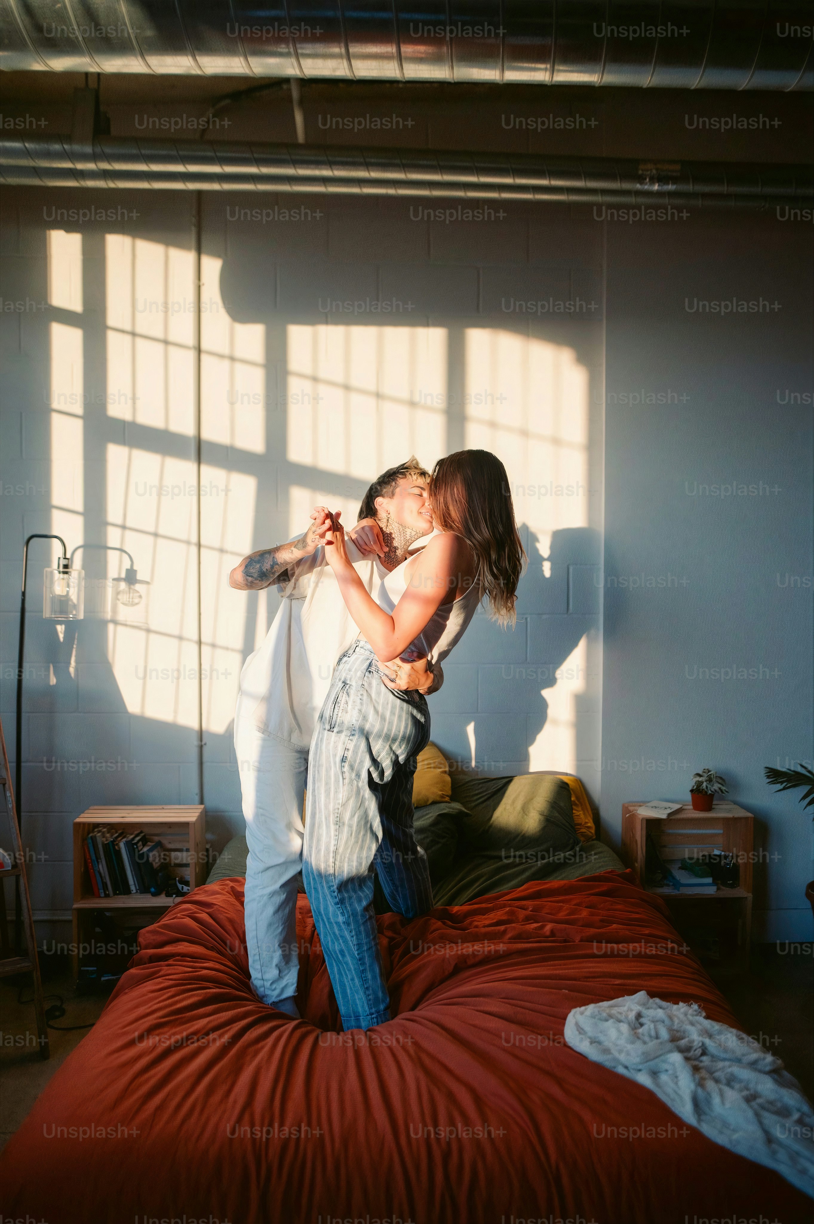 Una mujer parada encima de una cama junto a un niño foto – Imagen de ...