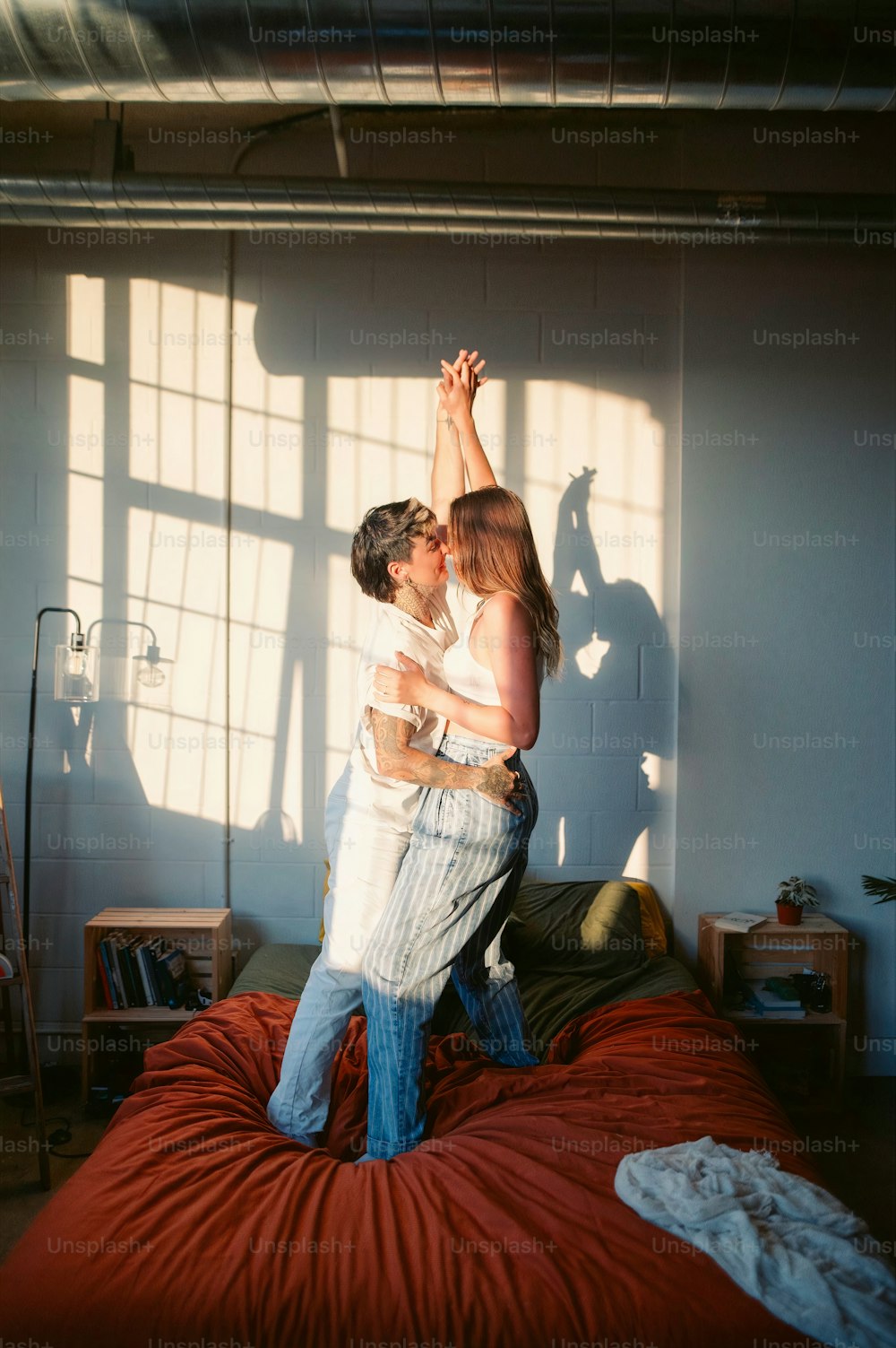 a man and woman standing on top of a bed