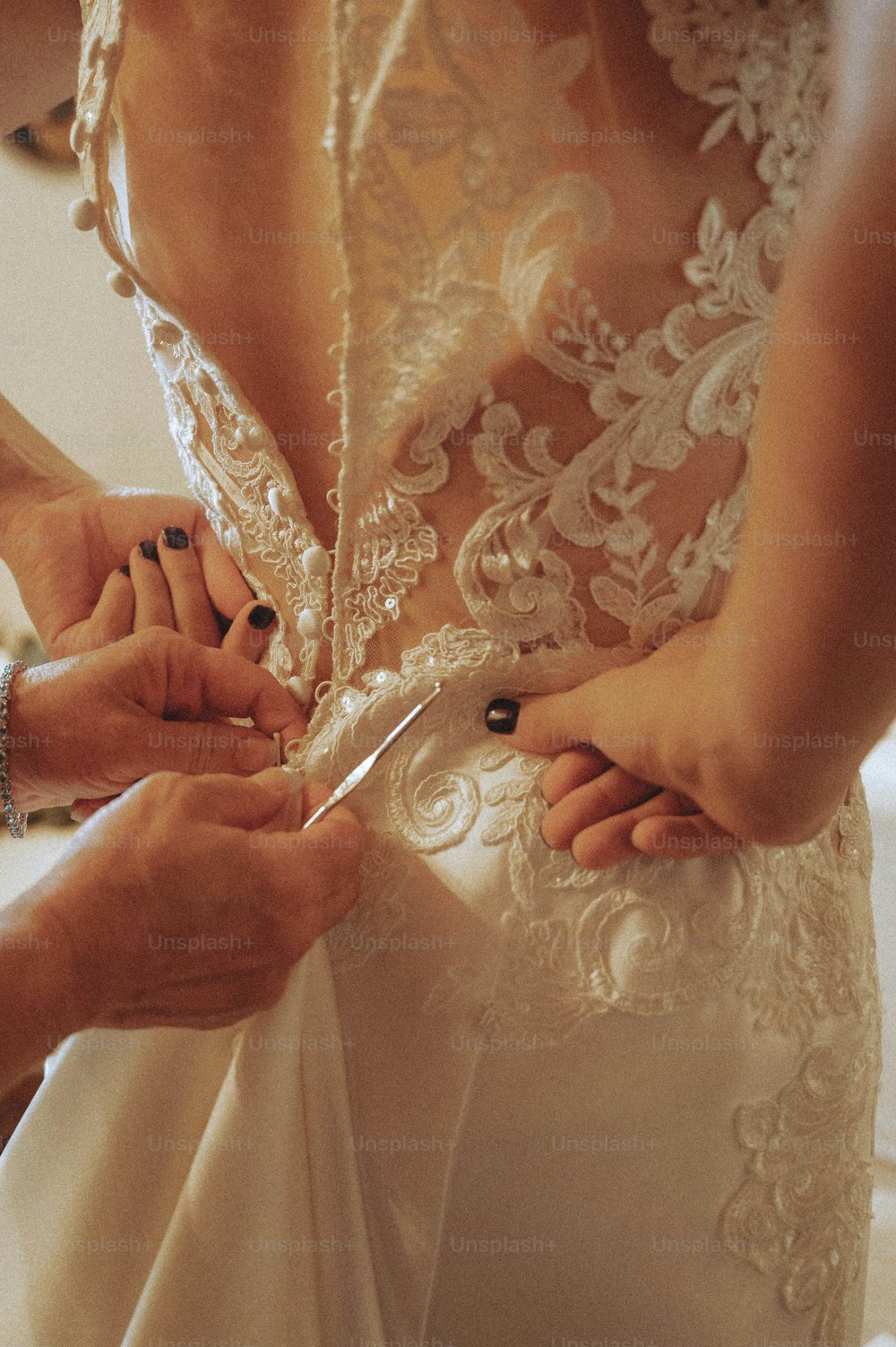 Eine Frau in einem Hochzeitskleid schneidet ein Stück Stoff