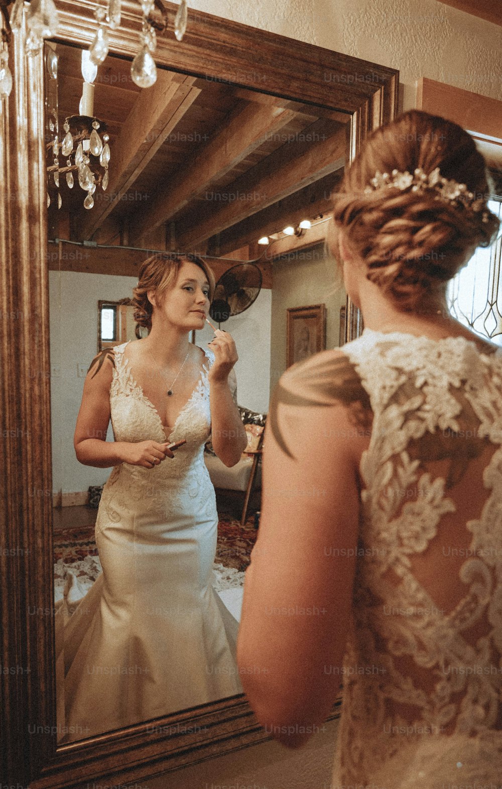 a woman in a wedding dress looking at her reflection in a mirror