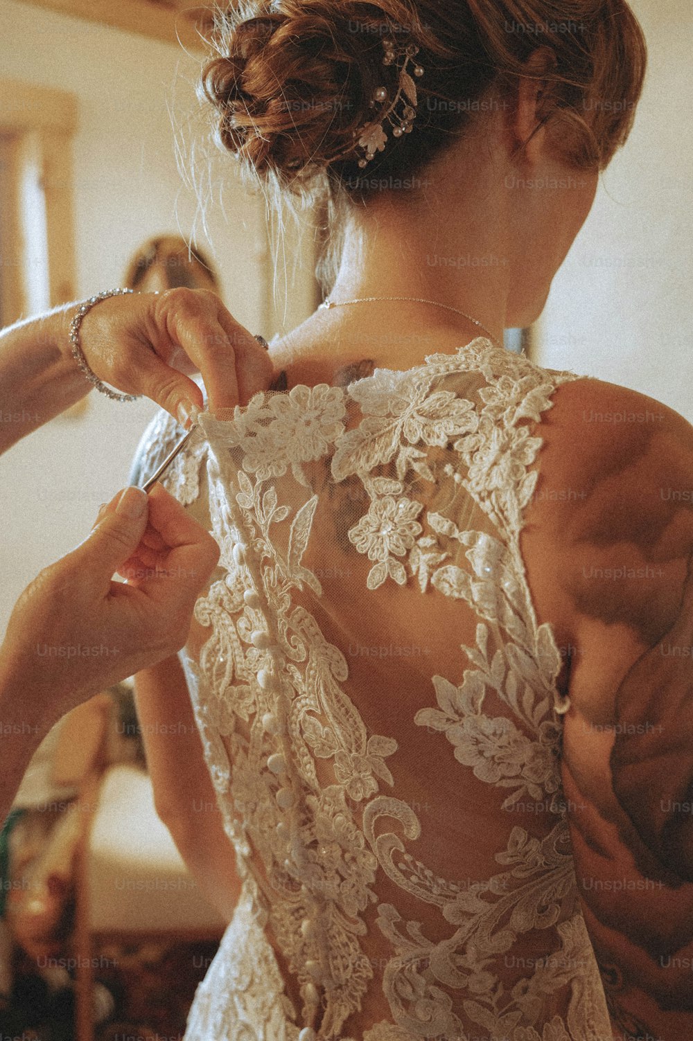 uma mulher em um vestido de noiva se preparando para seu casamento