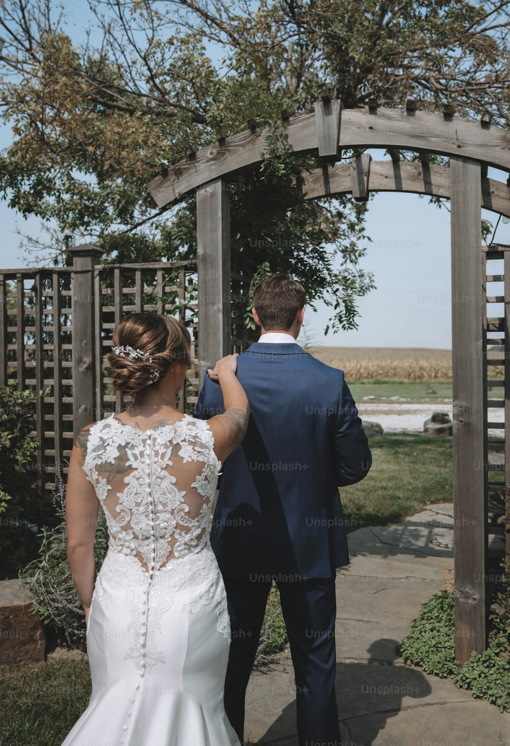 a bride and groom walking down a path
