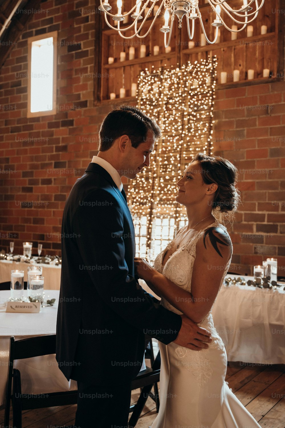 a bride and groom standing in front of a chandelier