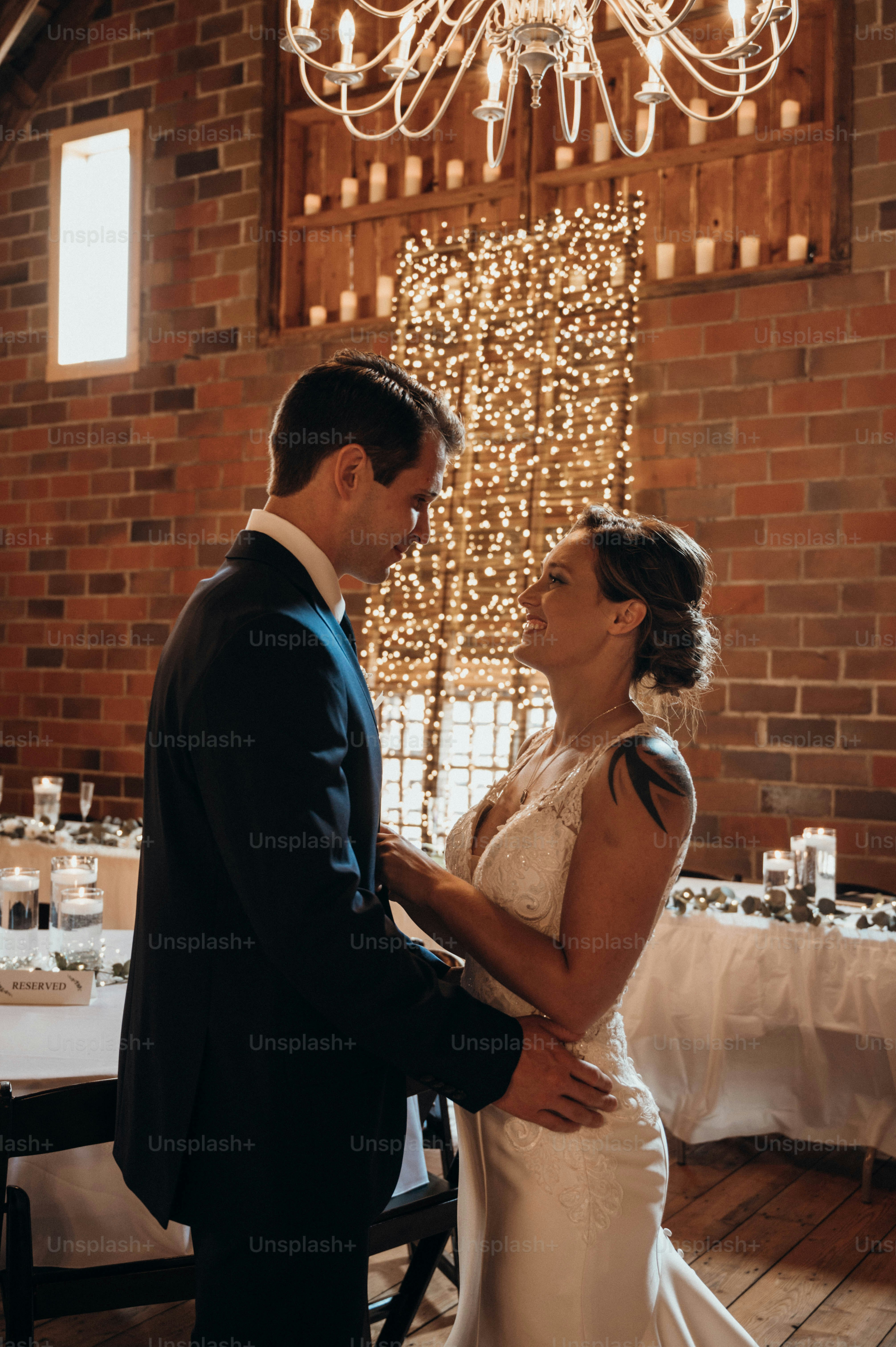 a bride and groom standing in front of a chandelier