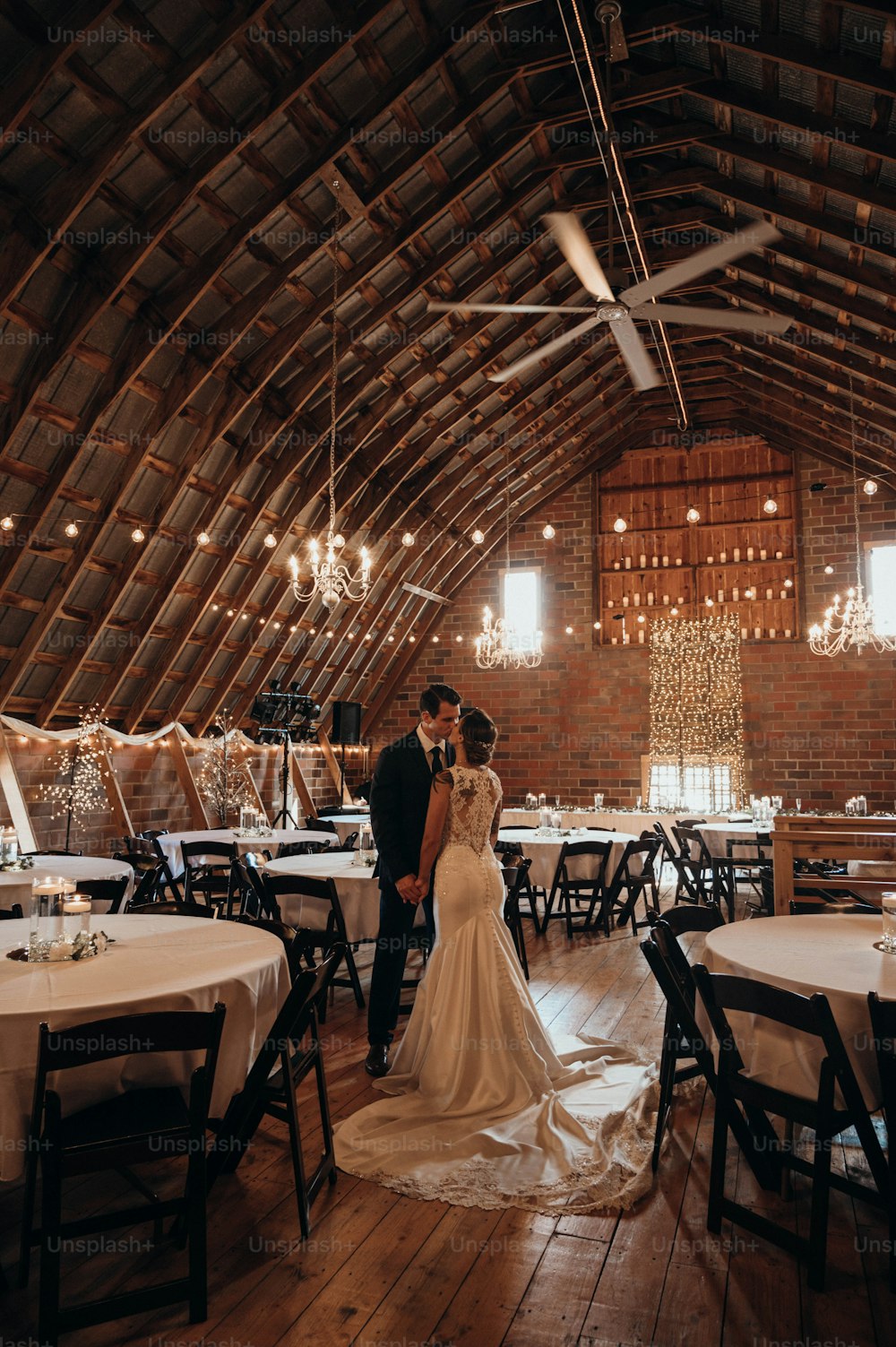 a bride and groom standing in a barn