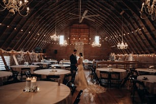 a bride and groom standing in a barn