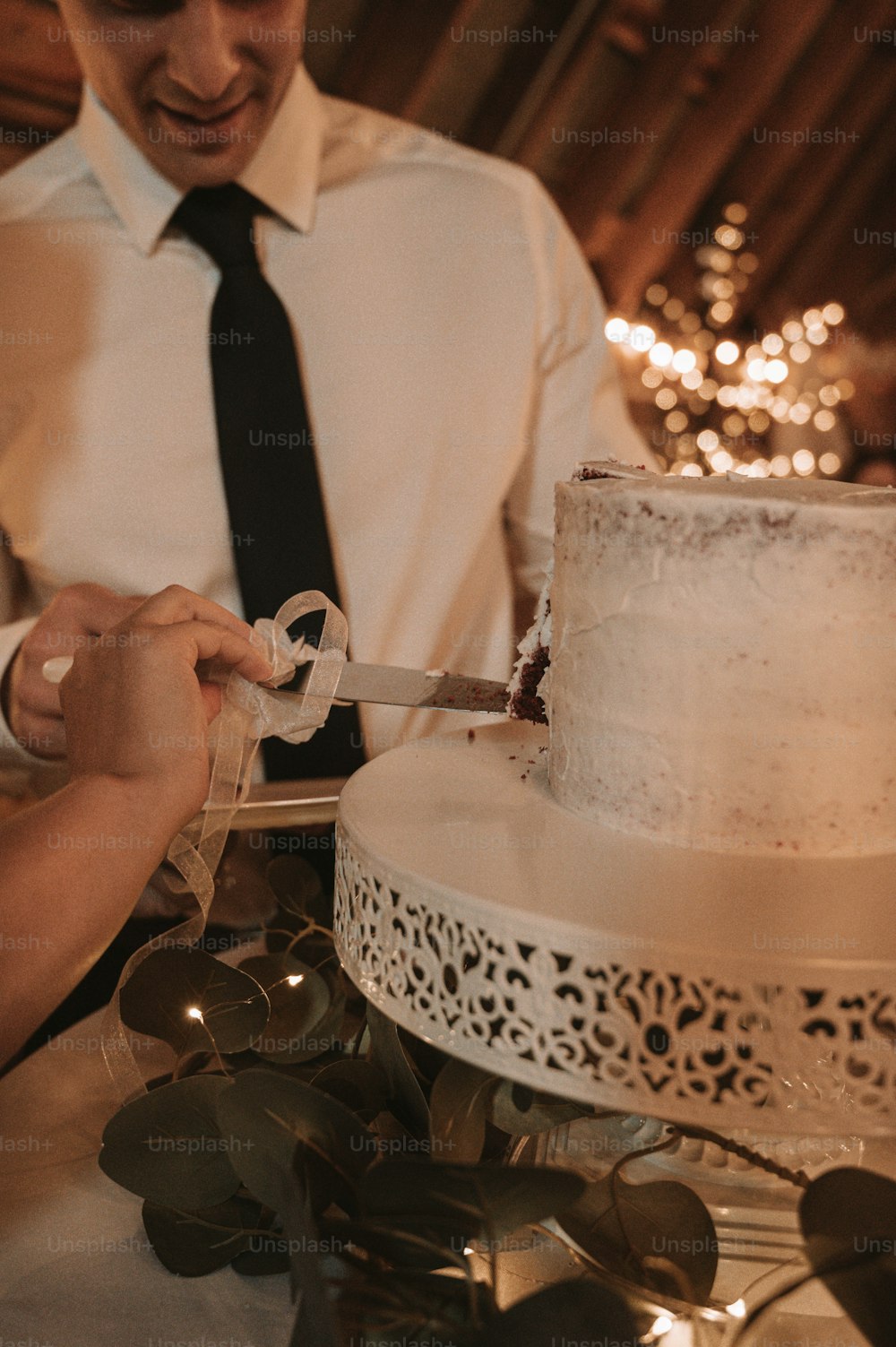 Braut und Bräutigam schneiden ihre Hochzeitstorte an