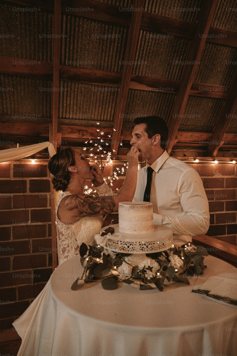 Braut und Bräutigam füttern sich gegenseitig mit einem Stück Kuchen