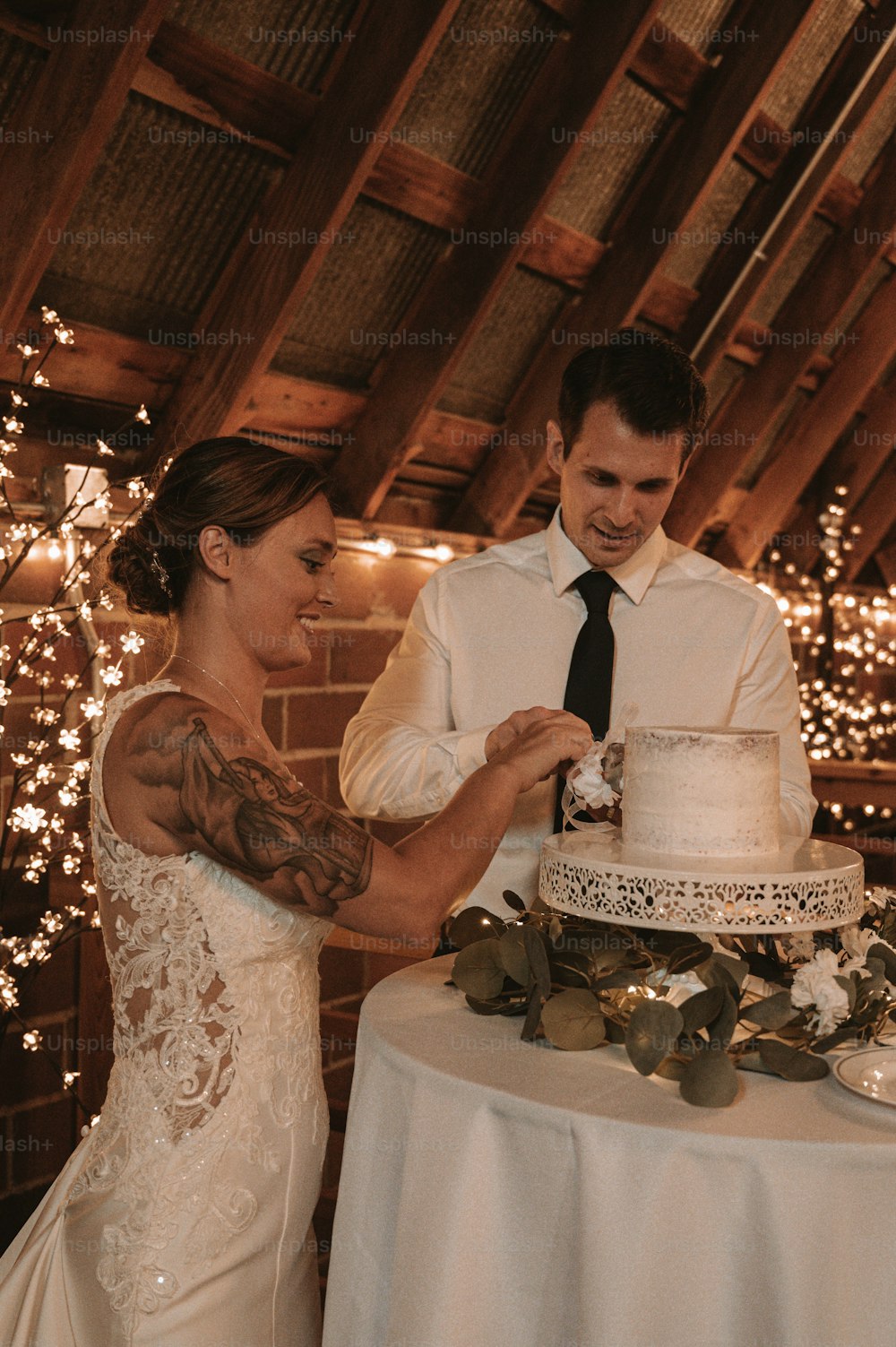 Braut und Bräutigam schneiden ihre Hochzeitstorte an