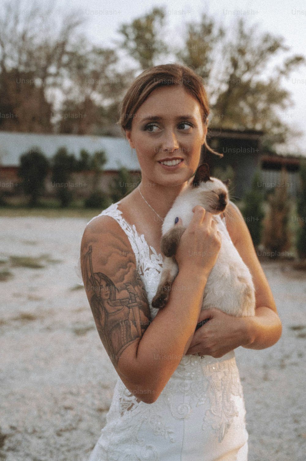 a woman in a white dress holding a small animal