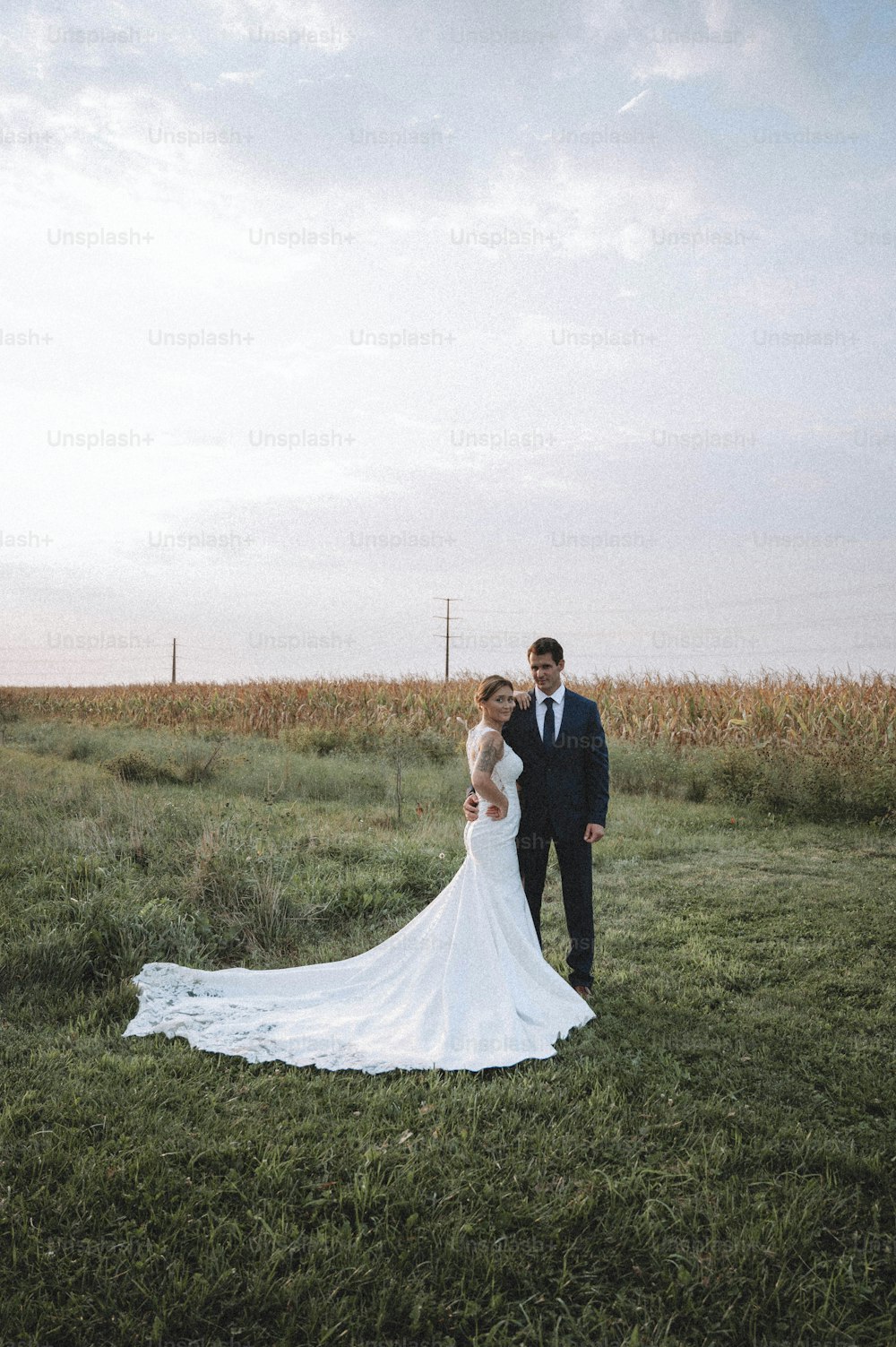 Una novia y un novio de pie en un campo
