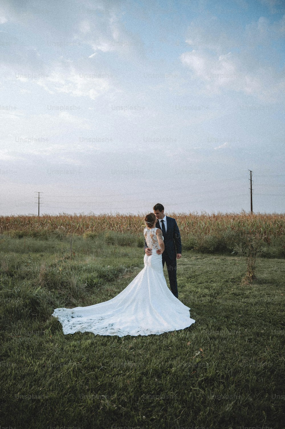 Una sposa e uno sposo in piedi in un campo