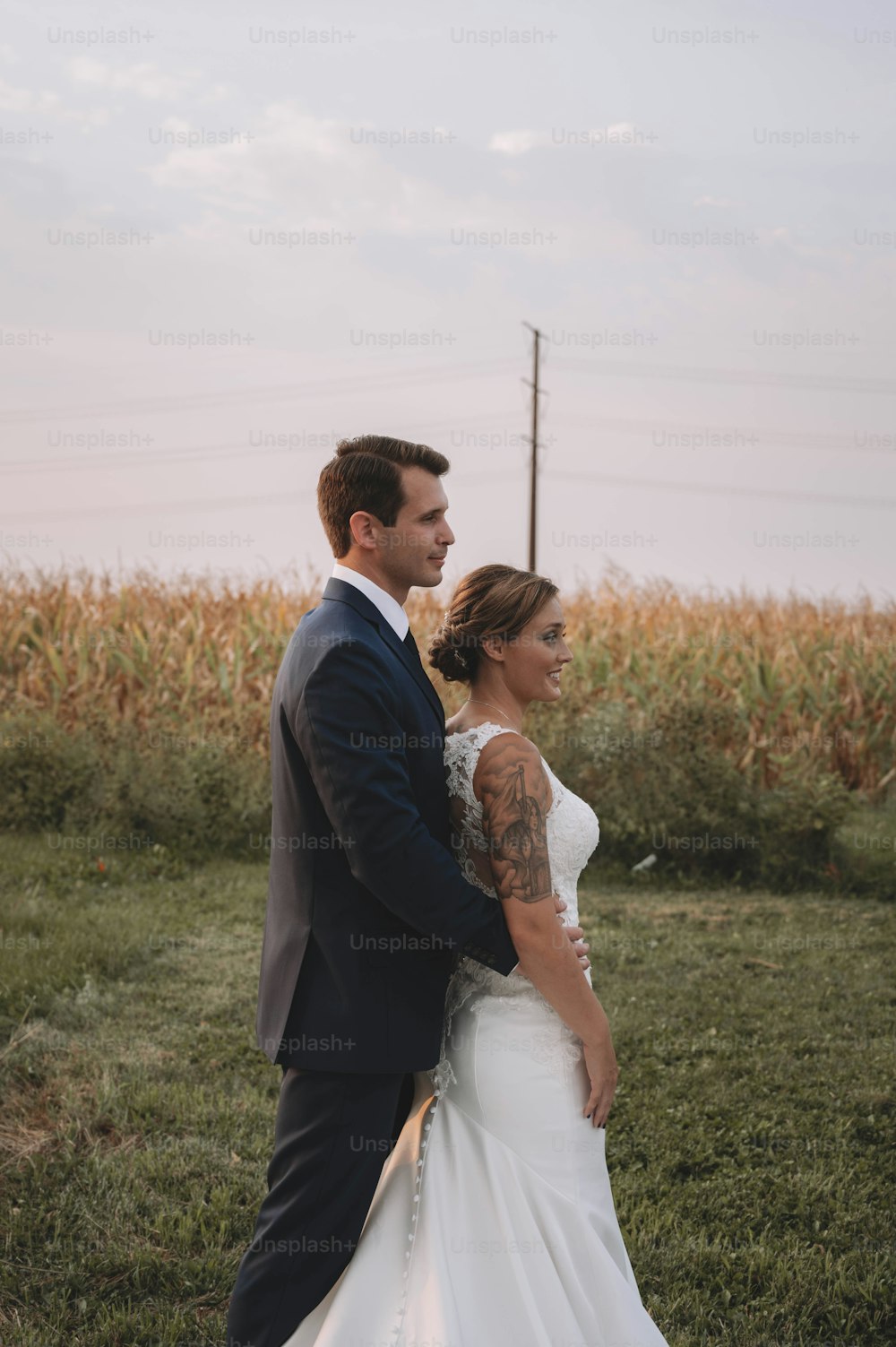 a bride and groom standing in a field