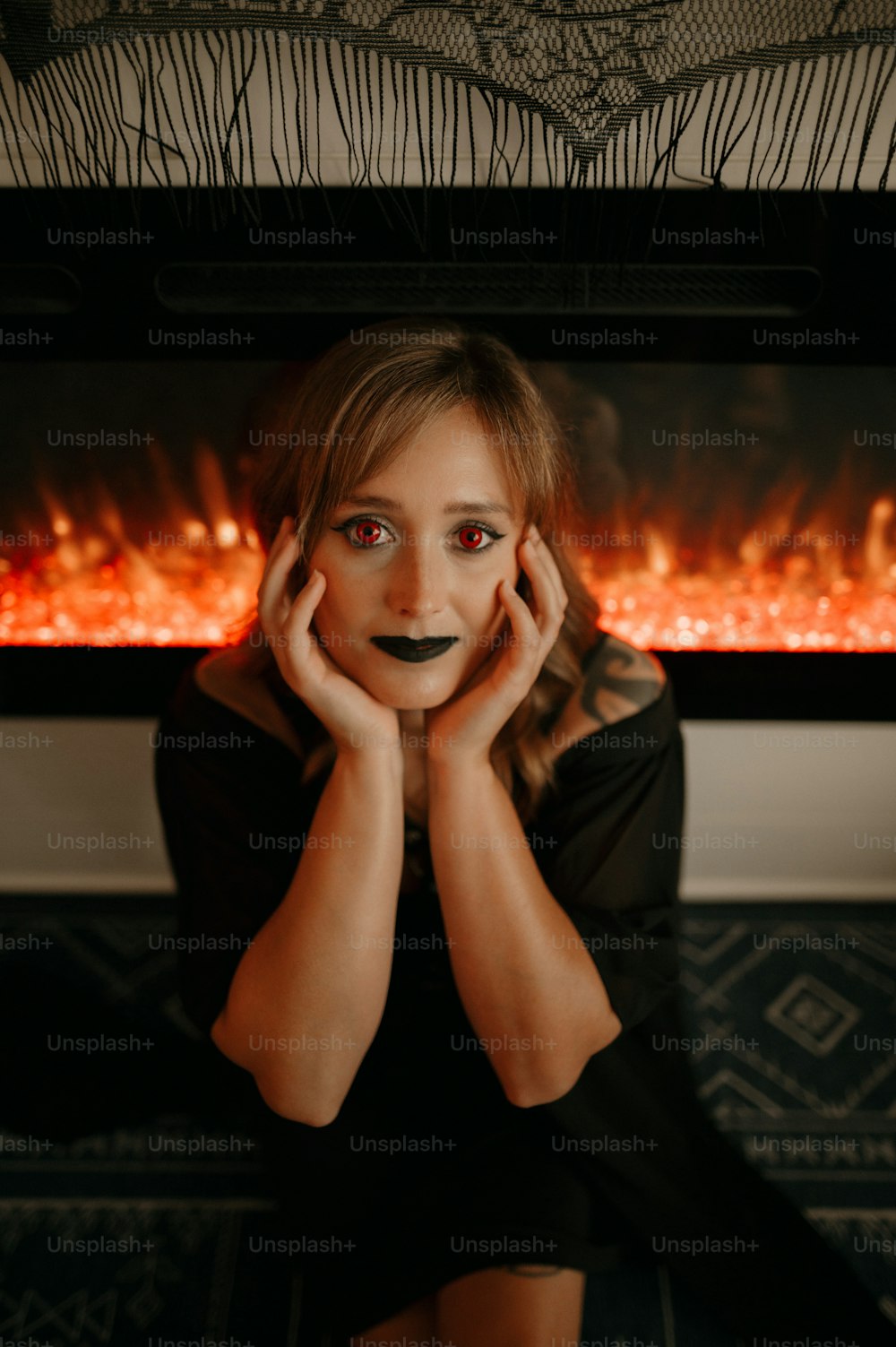 a woman with a fake face and a fake fireplace behind her