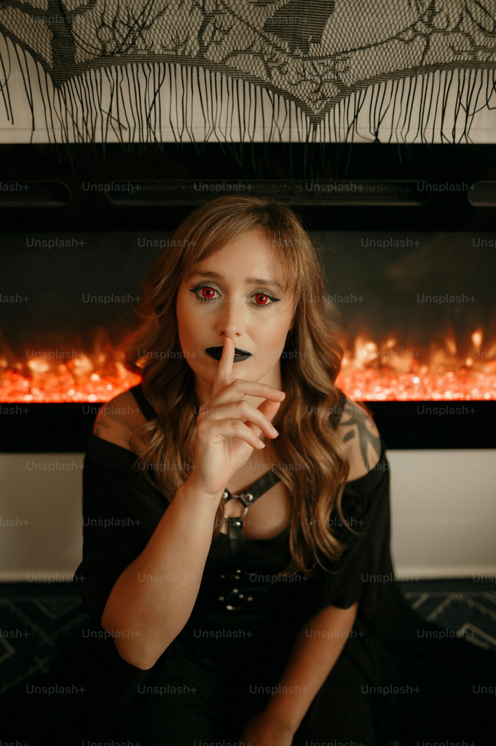 a woman sitting in front of a fire place