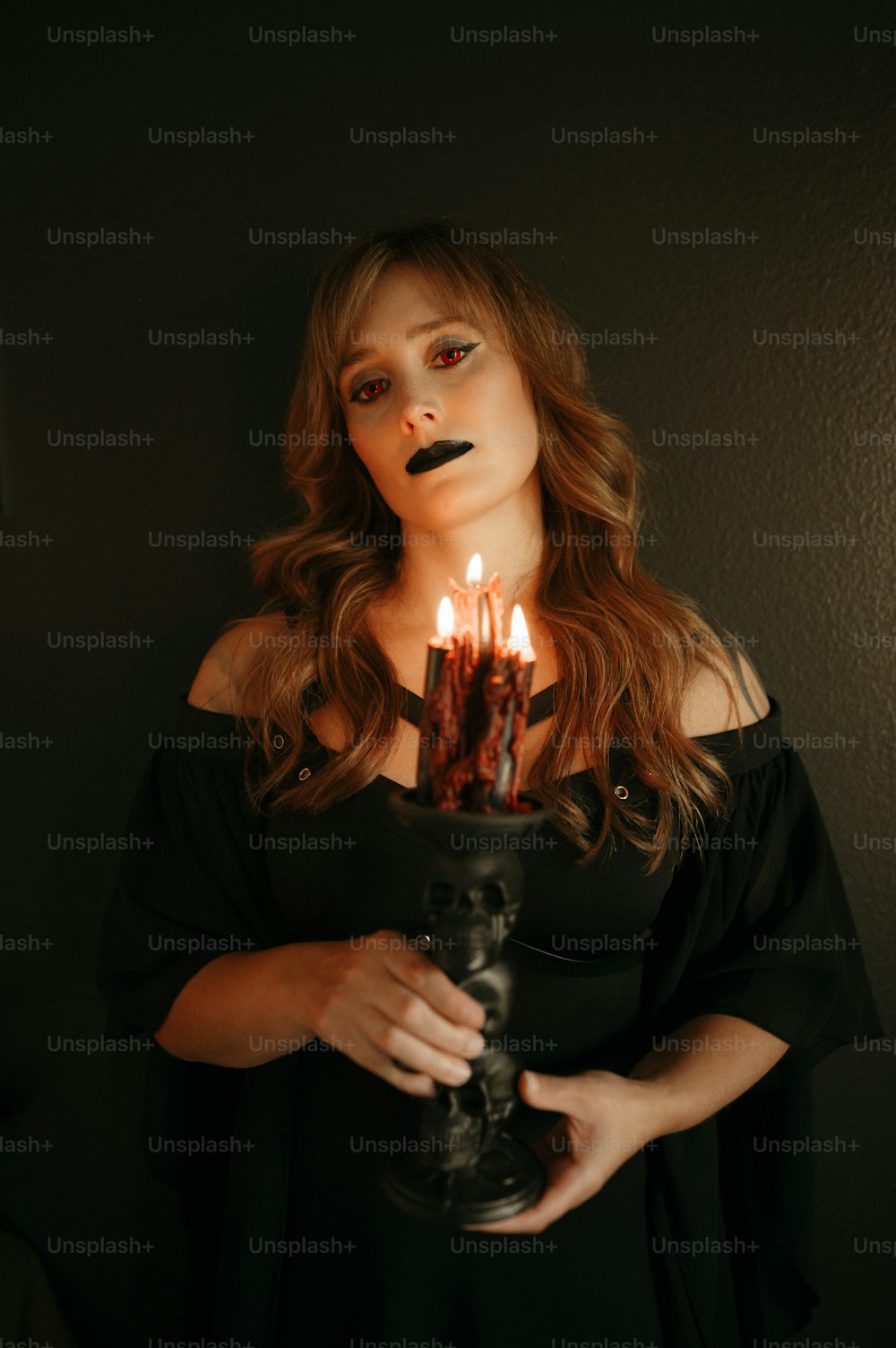 Eine Frau, die eine brennende Kerze in den Händen hält