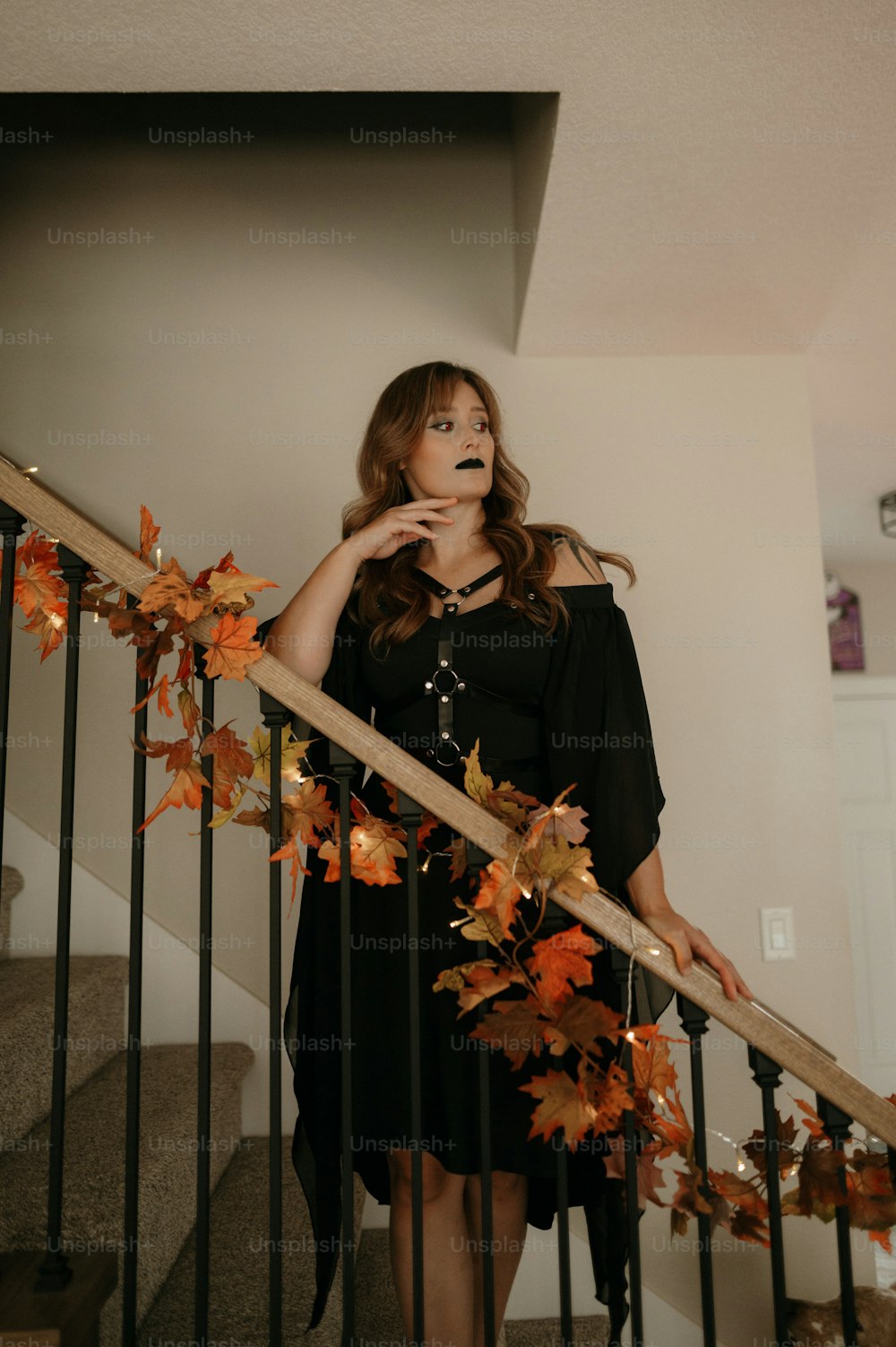 Une femme en robe noire debout sur une cage d’escalier